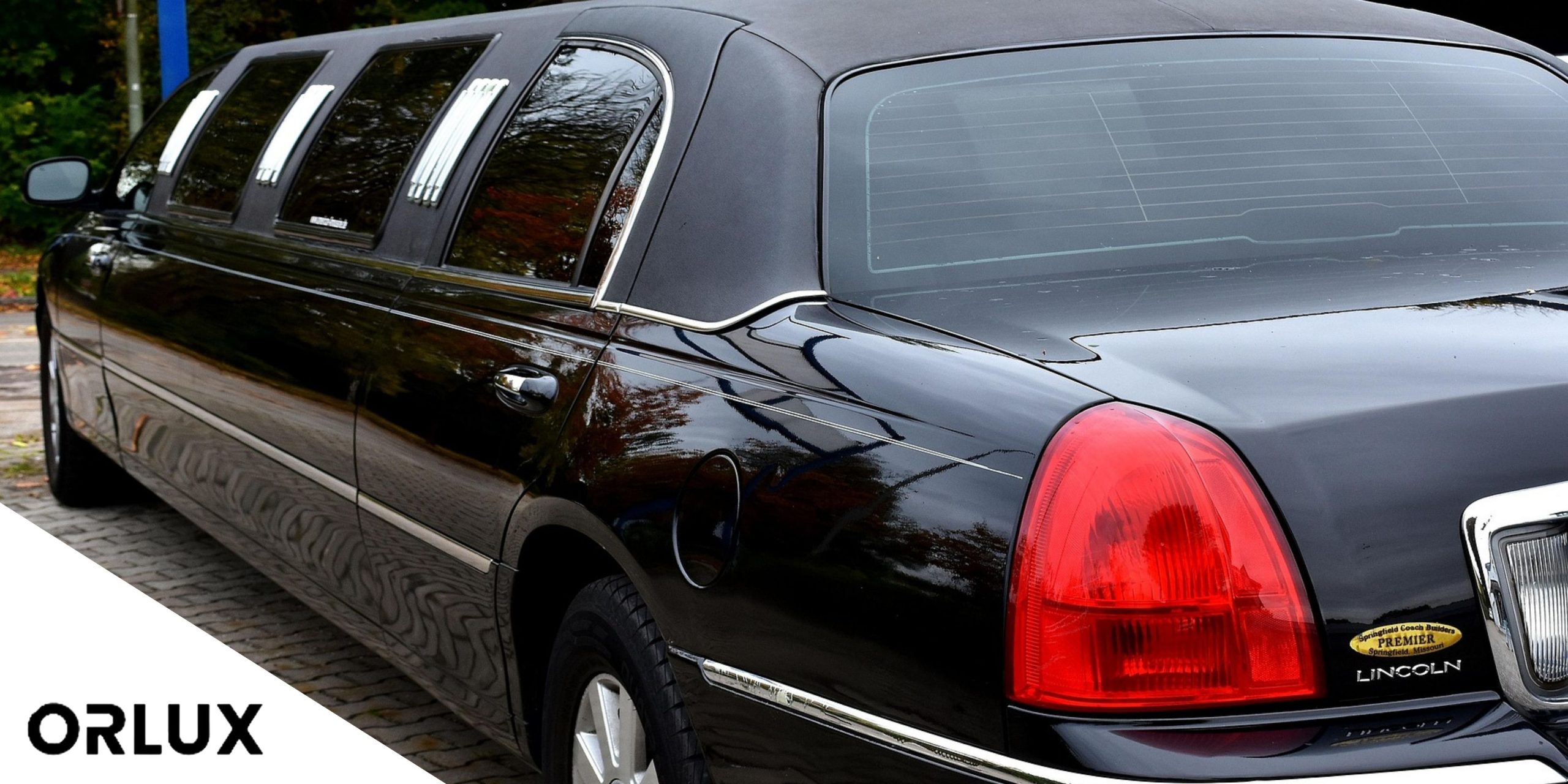 Black limousine parked on pavement.