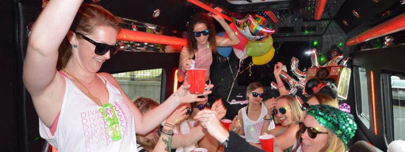 Party Bus Prices in Orlando: A Clear 2026 Cost Guide & Comparison 11 Bachelorette group in sunglasses raising red cups inside a party bus decorated with balloons
