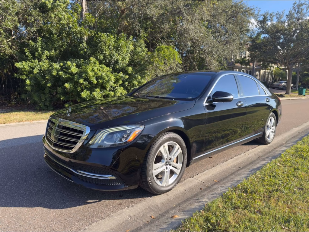 Black Mercedes-Benz S-Class sedan parked on a tree-lined Florida street