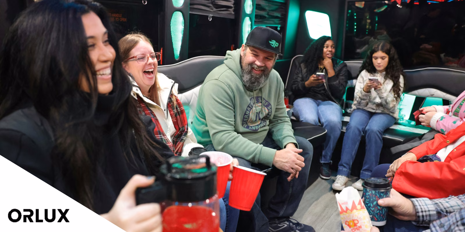Party Bus Prices in Orlando: A Clear 2026 Cost Guide & Comparison 1 Friends laughing with drinks on the leather seats of a party bus lit in green